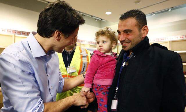 Syrian refugees are greeted by Canada´s Prime Minister Justin Trudeau (L) on their arrival from Beirut at the Toronto Pearson International Airport