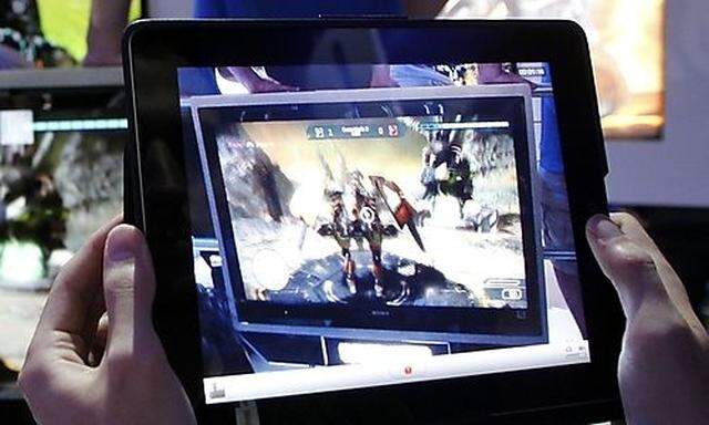 A man uses an Apple iPad to record a man playing Star Hawk on the PS3 during E3 in Los Angeles 