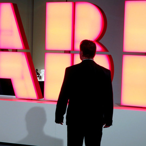 A man stands in front of the logo of Swiss engineering group ABB in Zurich