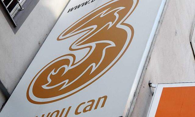 The logos of 'Orange' and '3' are pictured outside a telecommunications store in Vienna