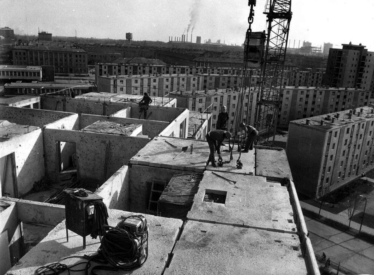 Mehrere tausend Arbeiter errichteten ab 1951 die Stahlfabrik und Wohnhäuser. Die von Architekt Tibor Weiner geplante Retortenstadt war ursprünglich für 25.000 Arbeiter geplant. Nur ein Jahr nach Baubeginn waren aber 40.000 Menschen nach Sztálinváros geströmt. Man musste schneller bauen.