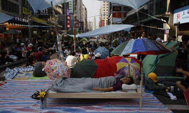 Pro-democracy protester sleeps on a bed as hundreds block Nathan Road at Hong Kong´s Mongkok shopping district