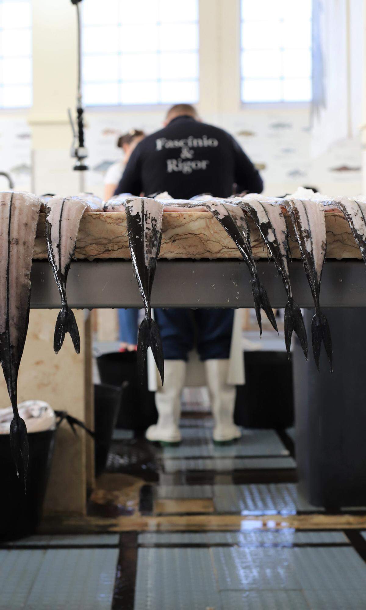 Allgegenwärtig ist der Schwarze Degenfisch, ein langer Tiefseefisch mit weißem Fleisch und schwarzer Haut. Diese wird von den Arbeitern im Fischmarkt mithilfe von Orangennetzen heruntergerubbelt. 