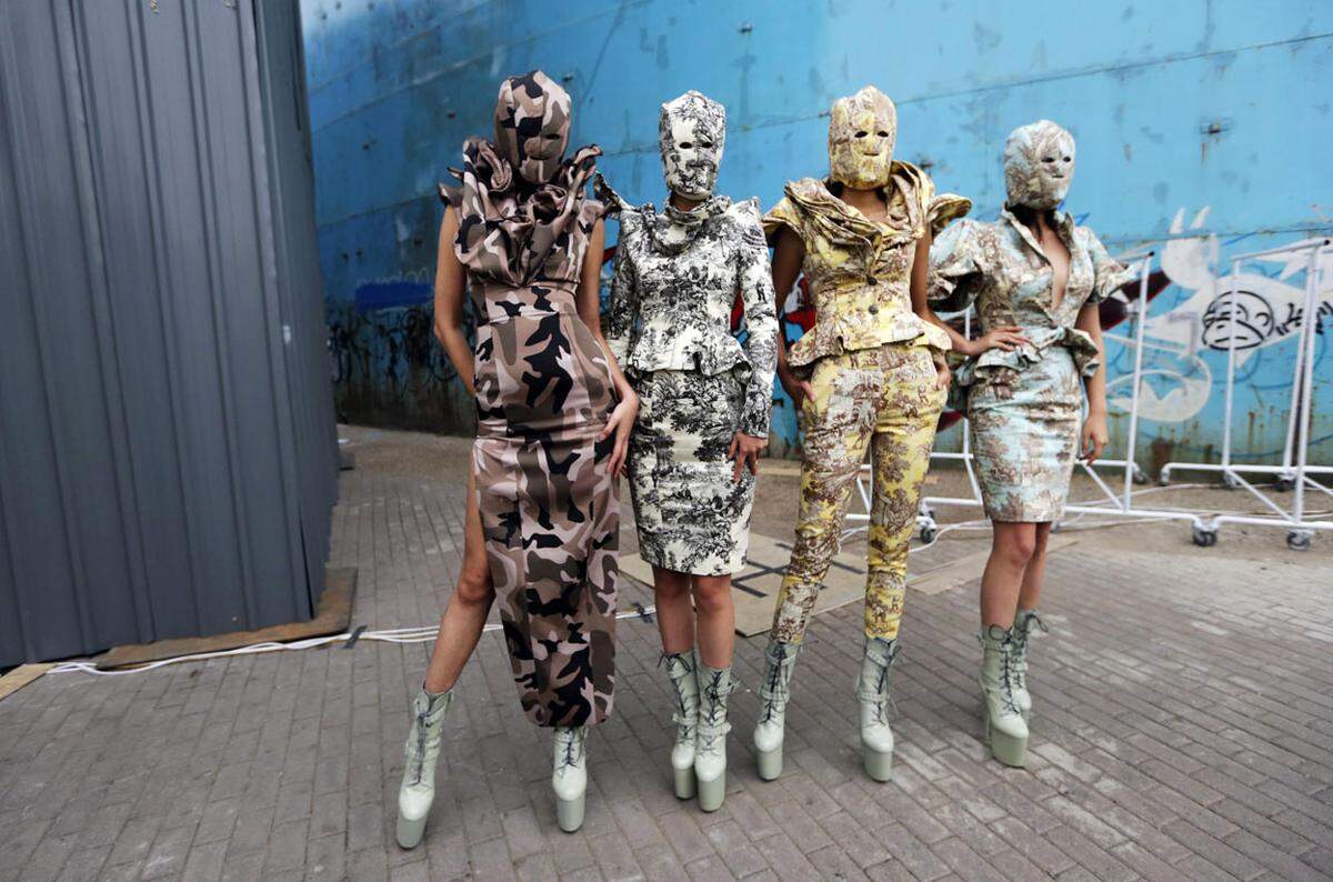 Auch wenn China in Sachen Fashion Weeks nicht zu den großen Modemetropolen wie New York oder Mailand gehört, kann die Modewoche in Peking mit auffälligen Modekreationen mithalten. Vor der Show des Labels Heyunciye posieren die Models in Camouflage-Outfits. 