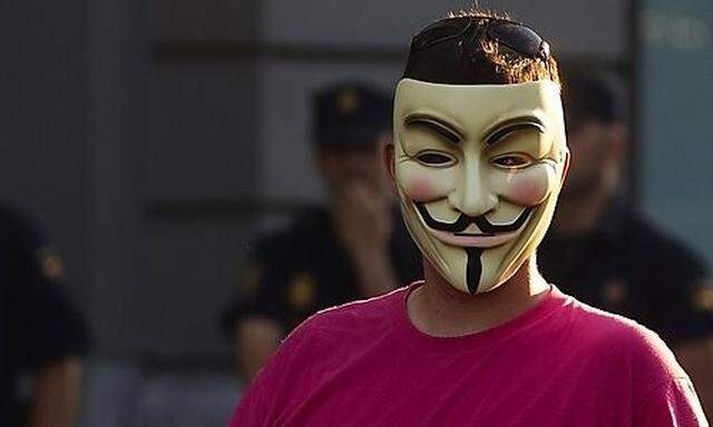 A demonstrator wearing an Anonymous group mask attends an assembly against the Euro Pact and the 