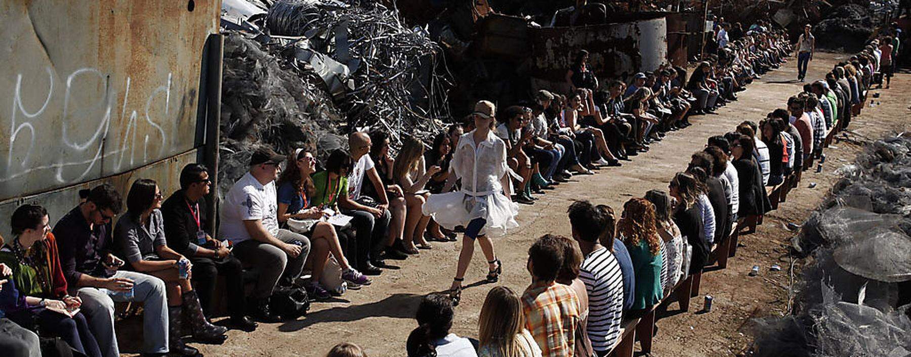 Model presents creation from Cavalera Summer 2012/2013 collection at a junkyard, during Sao Paulo Fashion Week