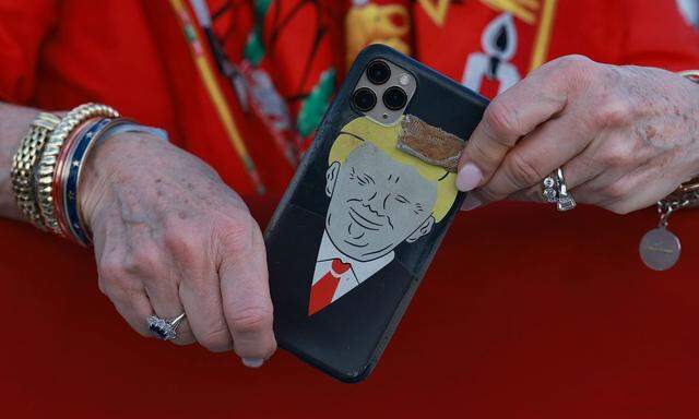 Symbolbild: Unterstützerin von Trump hält Handy mit Hülle, die sein Konterfei zeigt