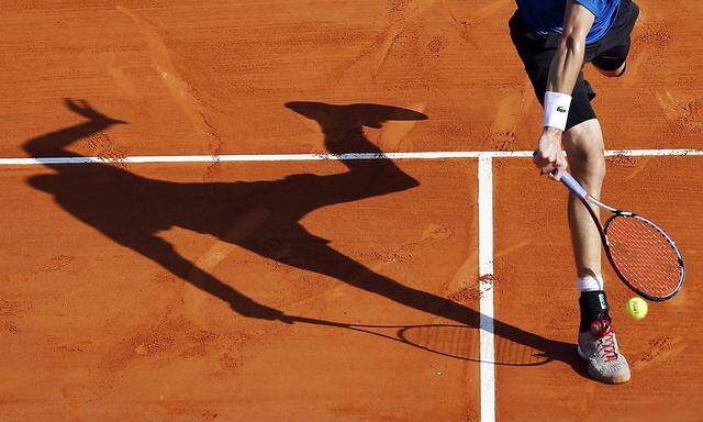 John Isner of the US casts his shadow as he returns the ball to his compatriot Steve Johnson during their match at the Monte Carlo Masters in Monaco