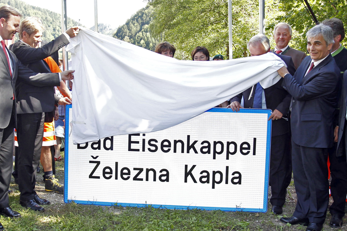 Es ist ein historischer Verhandlungserfolg: Nach Jahrzehnten des Hickhacks einigen sich das Land Kärnten, die Bundesregierung und zwei der drei Slowenenorganisationen in der Ortstafel-Frage. Der Kompromiss sieht 165 zweisprachige Schilder vor. Im Nationalrat stimmen nur drei Grün-Mandatare gegen die als endgültige Lösung des Ortstafel-Konflikts gepriesene Einigung.