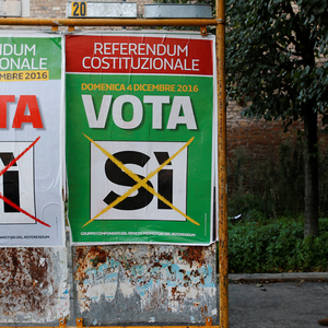 A man walks next to a poster in support of the ´Yes´ vote in the upcoming constitutional reform referendum in Rome