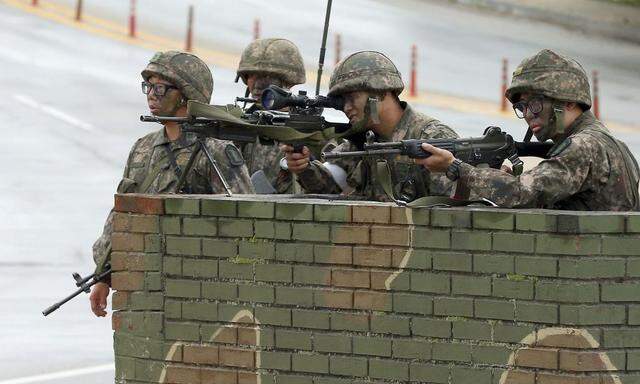 Soldiers stand guard at a temporary checkpoint during a search for a conscript soldier on the run after a shooting incident, in Goseong