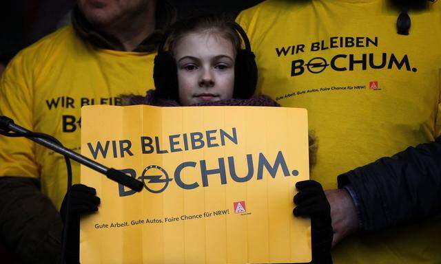 A girl holds a placard at a solidarity festival for carmaker Opel in Bochum