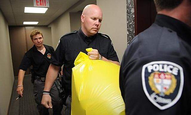 A police officer removes a package from the Conservative Party headquarters in Ottawa, Ontario, on Tu