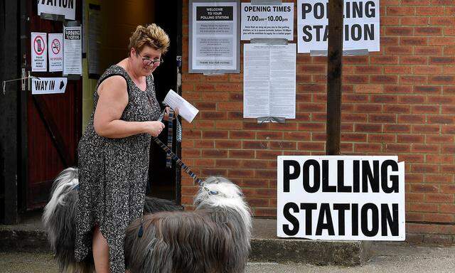 A woman with her dogs is pictured outside a polling station, where Britain's Prime Minister Theresa May voted in the European Parliament Elections, in Sonning