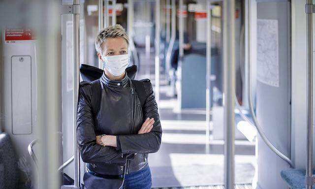 Eine Frau steht in einer S-Bahn der Berliner Verkehrsbetriebe. Sie traegt einen Mundschutz. Berlin, 13.04.2020. Aktuell