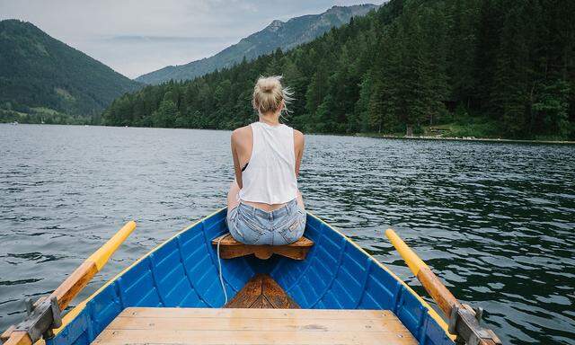 Woman Sitting On Boat In Lake