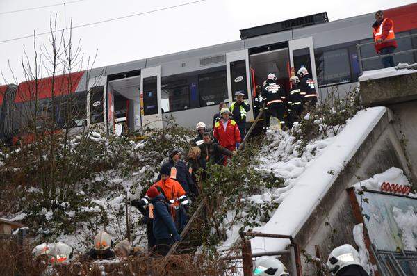 Begleitet von Rettungskräften verlässt der letzte Schwung nahezu unverletzter Passagiere gehend die S-Bahn.