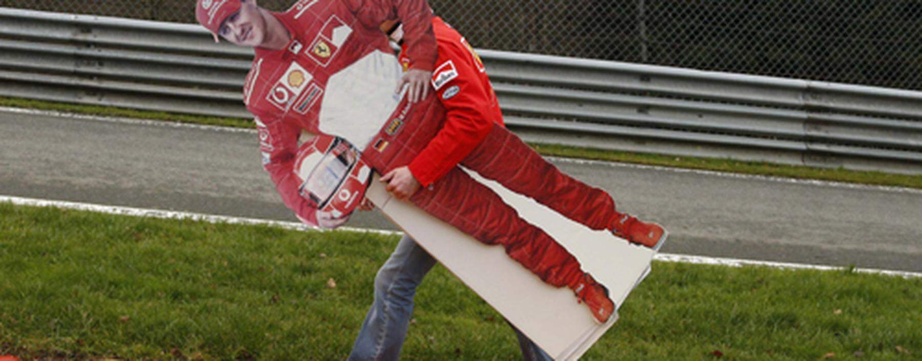 A fan holds up a cardboard cut-out of seven-times former Formula One world champion Michael Schumacher during a tribute at the Circuit of Spa-Francorchamps