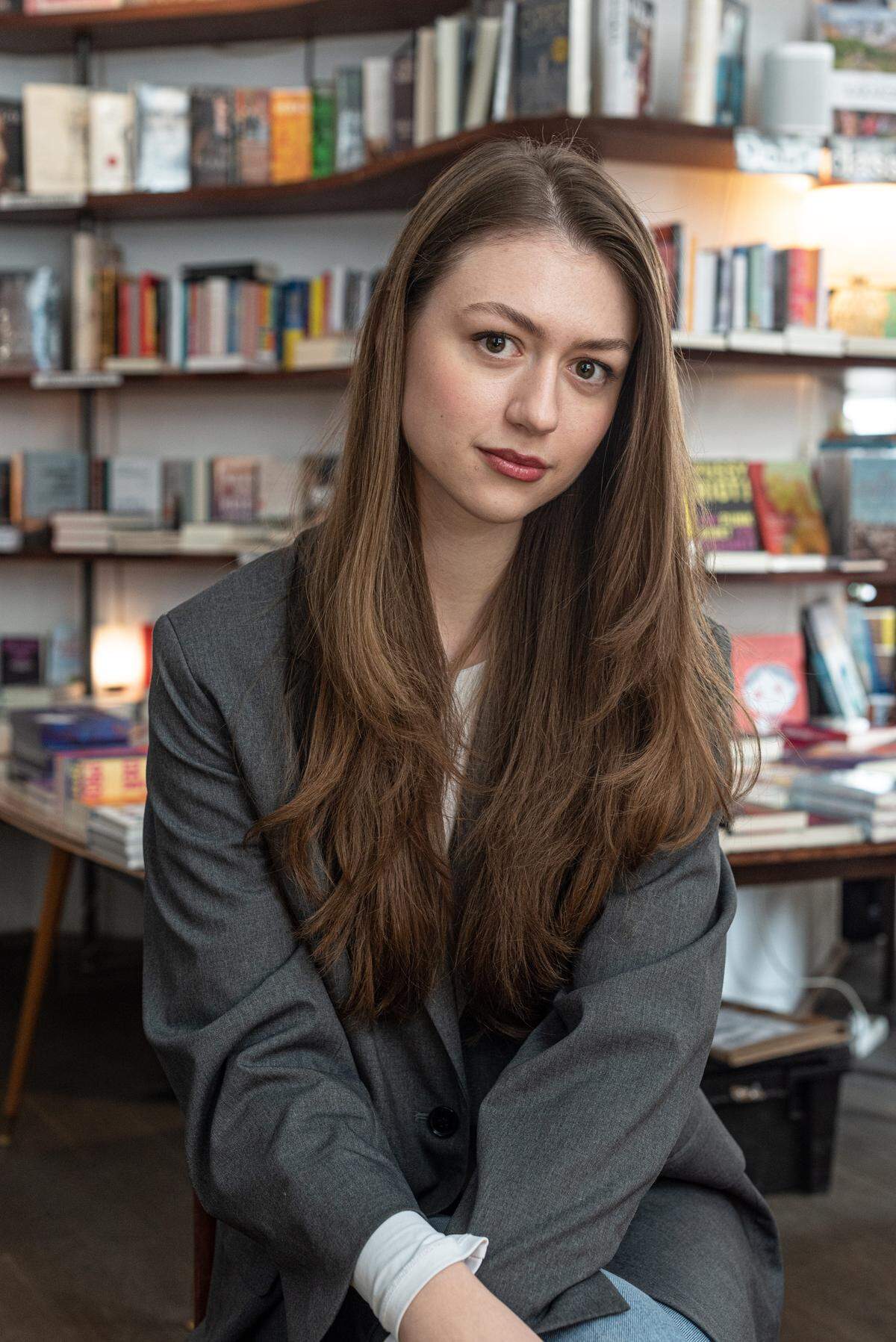 Die 23-jährige Kristina Stojanović, hier fotografiert im Café Phil in Mariahilf, studiert Jus in Wien und kommt ursprünglich aus Serbien. Das Lesen war bei ihr schon lang vor Tiktok da, vielleicht stellt sie gerade deswegen in ihren Kurzvideos auch Klassiker, serbische Belletristik oder zeitgenössische Literatur vor: Bücher, die beim Algorithmus teilweise wenig Anklang finden, während sie ein beliebteres Genre wie „New Adult“ kaum liest. Das Verlangen, über Bücher zu sprechen, hat sie – im Kontrast zu ästhetischen Lektürefotos auf Instagram – auf BookTok geholt. Dass so viele erst zum Lesen kommen, begeistert sie, und mittlerweile greift sie selbst hin und wieder zu einem BookTok-Buch.