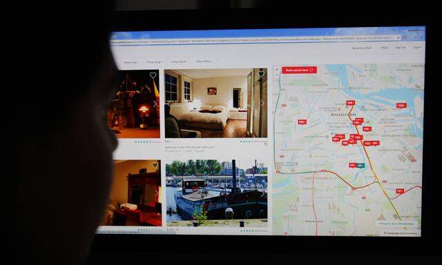 A picture shows a woman looks the map online of the lodging service Airbnb displayed on a smartphone