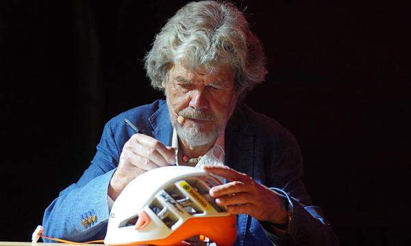 Reinhold Messner beim Signieren eines Kletterhelms.