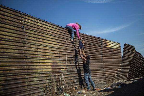 Migranten aus Zentralamerika klettern über einen Zaun zwischen Mexiko und den USA. Der Fotograf ist Pedro Pardo.