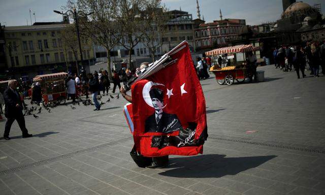 Die Türkei und ihre Idole. Ein Straßenverkäufer mit einer türkischen Flagge, die Staatsgründer Atatürk zeigt.