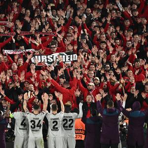 Die Leverkusen-Spieler feiern nach Spielende mit den mitgereisten Fans.