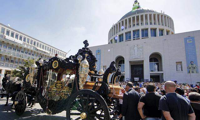 An ornate hearse pulled by six, black-plumed horses, carries the body of Vittorio Casamonica to a Roman Catholic basilica in the Rome suburbs, where the funeral mass was celebrated