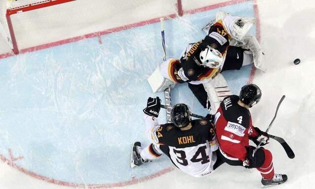 Germany's goaltender Endras and Kohl are challenged by Canada's Hall during their Ice Hockey World Championship game at the O2 arena in Prague