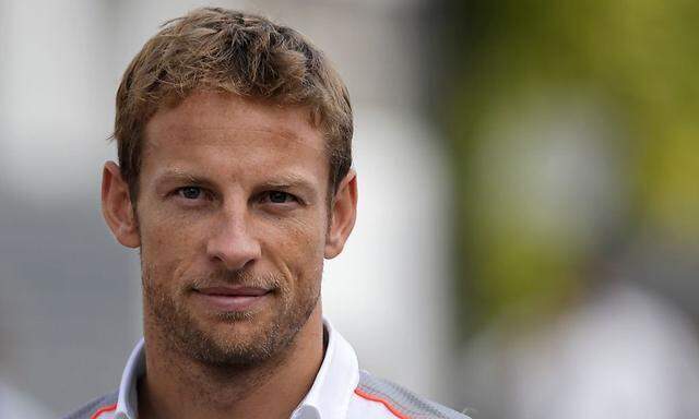 McLaren F1 driver Jenson Button of Britain arrives at the paddock ahead of the Singapore F1 Grand Prix