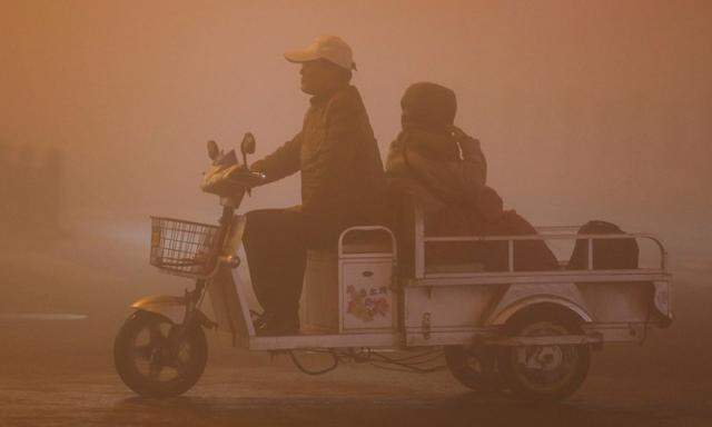 Zwei Personen fahren durch starken Smog