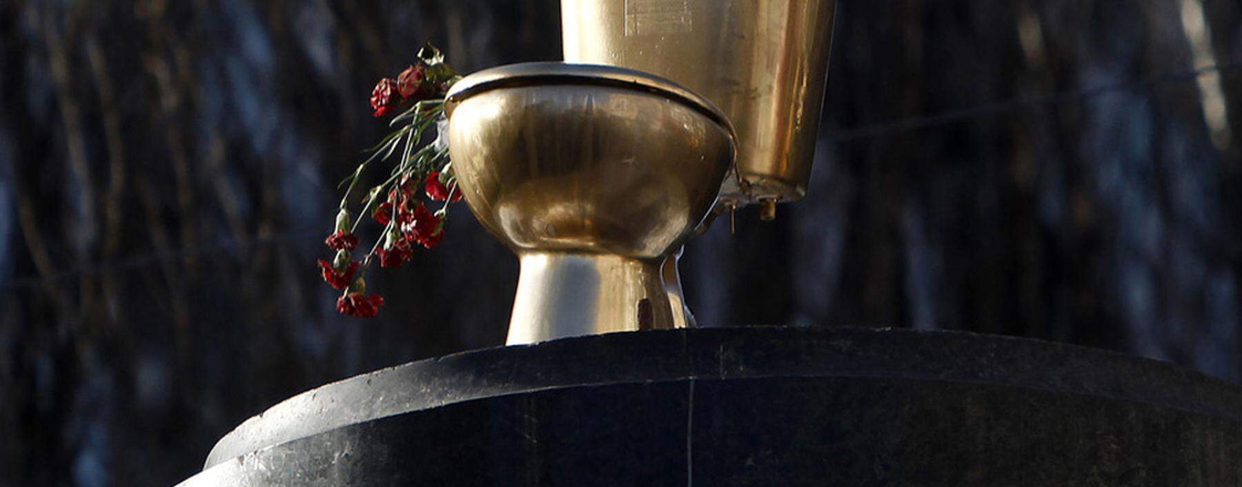 A toilet bowl is seen on the pedestal of a statue of Soviet state founder Vladimir Lenin, which was toppled by protesters last December, in Kiev