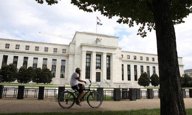 FILE PHOTO: FILE PHOTO: A cyclist passes the Federal Reserve building in Washington, DC