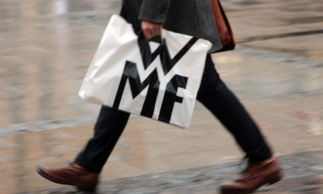 Passant traegt eine Plastiktuete mit Signet und Schriftzug WMF in der Innenstadt Muenchen Bayern Deut