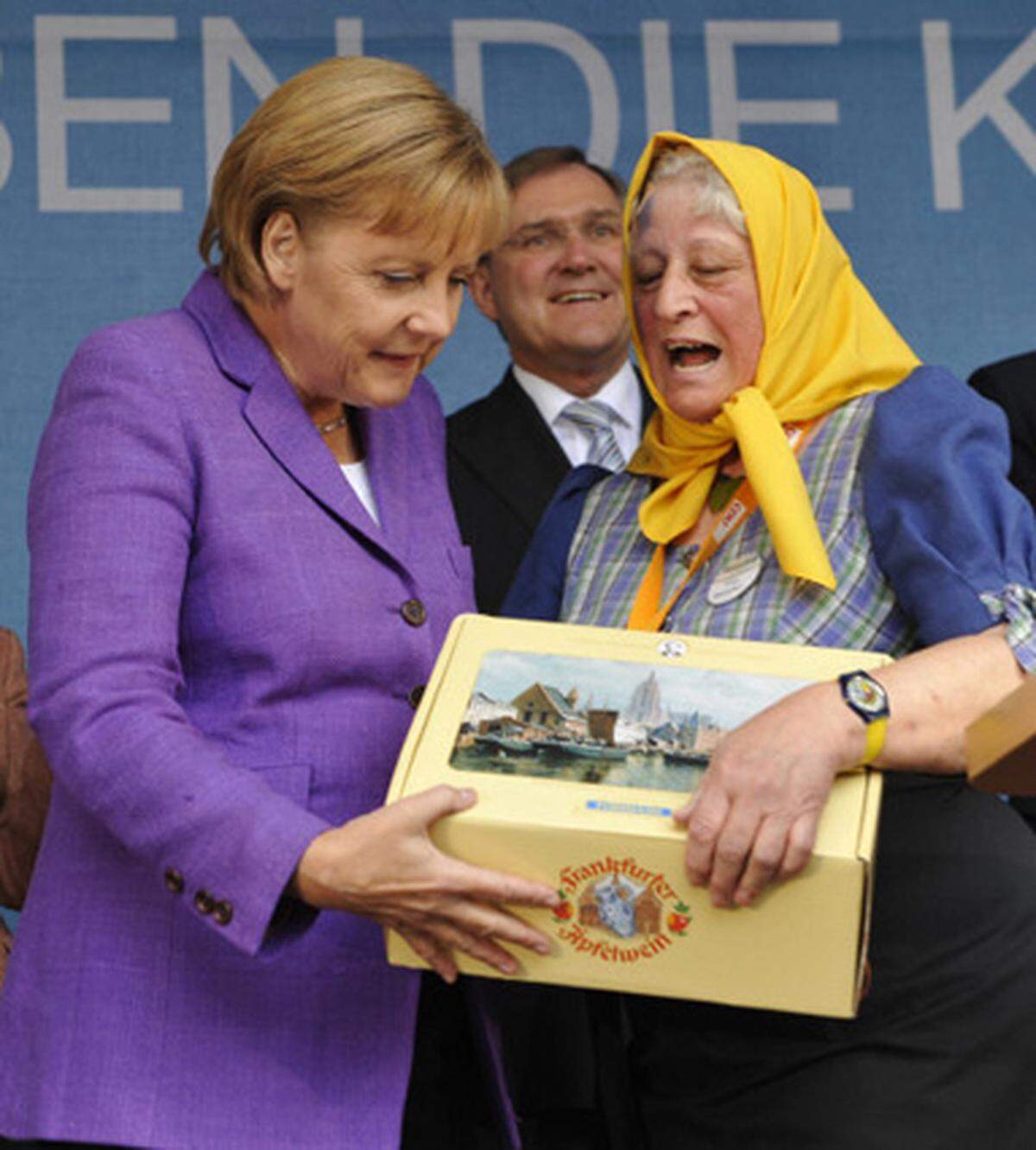 Sonst teilen die Politiker Wahlsgeschenke aus - ab und zu ist es auch umgekehrt: Angela Merkel nimmt hier eine Schachtel mit der Frankfurter Spezialität "Applewoi" entgegen.