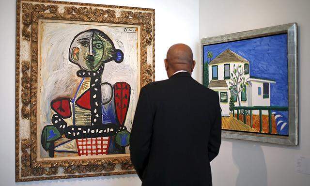 A security guard views Pablo Picasso´s ´Femme au chignon dans un fauteuil´ and David Hockney´s ´Malibu House´ at a pre-auction viewing of property from the Goldwyn family collection at Sotheby´s in Los Angeles