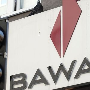 A pigeon sits atop the logo of Austrian lender BAWAG PSK next to traffic lights at a branch office in Vienna