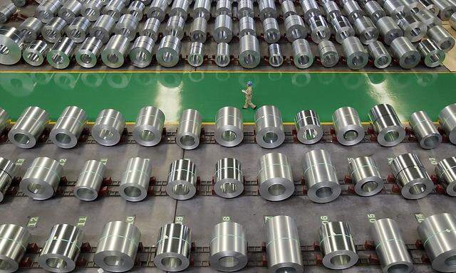 File photo of an employee walking past columns of steel as she works at a steel production factory in Wuhan