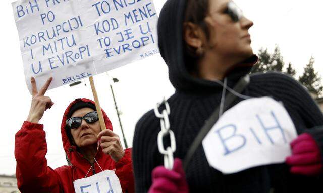 An anti-government protester holds a placard that reads, ´Bosnia first in corruption in Europe´ during a protest in Sarajevo