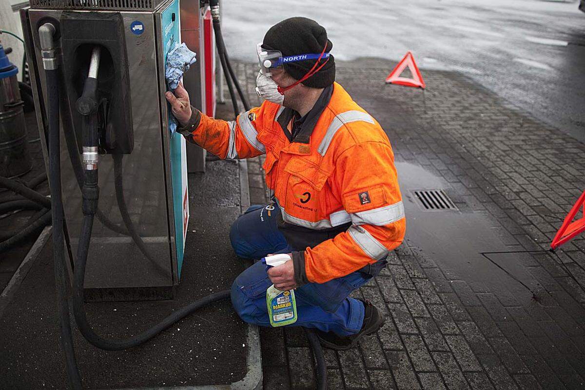 Mit Besen, Bürsten und viel Wasser kämpfen die Isländer gegen die Asche, die bis in kleinste Poren eingedrungen ist.