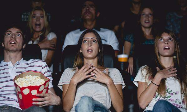 Audience in movie theater with shocked expressions