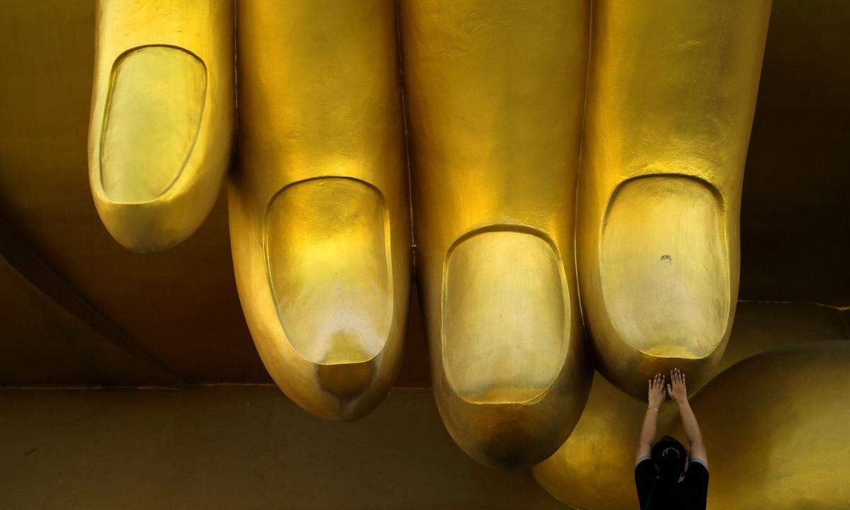 Die riesige Buddhastatue im Ang Thong (Thailand) - Menschen, die ihr über die Finger streichen, erwarten sich davon Glück.