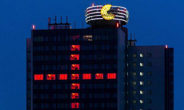 Ein Kreuz aus roten Lichtern an der Fassade des Hotels Dormero im SI-Centrum in Stuttgart wird zum stillen Mahnmal gegen