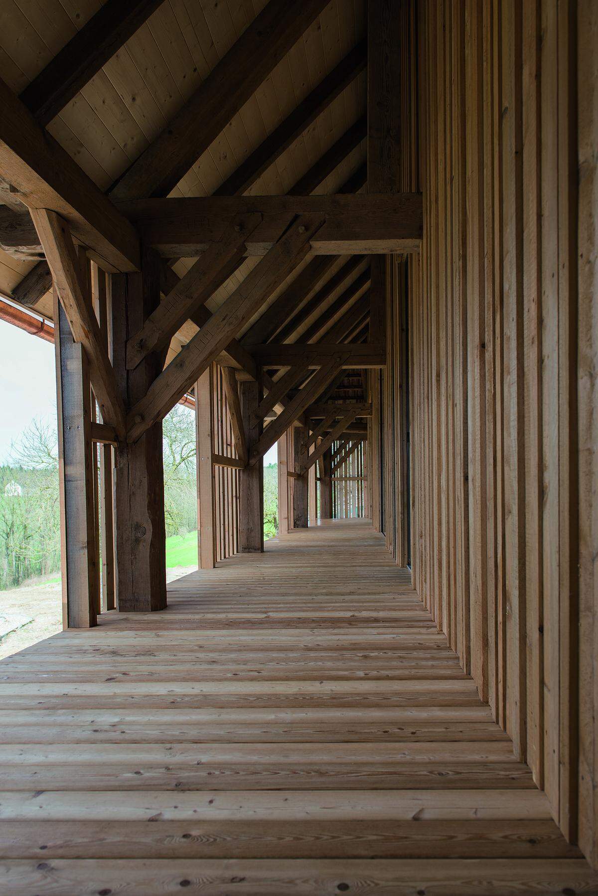 Auf dem Balkon ist die feingliedrige Holzkonstruktion der ehemaligen Tenne sichtbar.