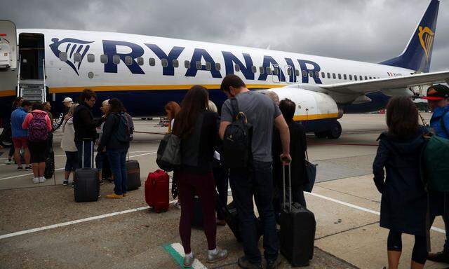 Passengers wait to board a Ryanair flight at Gatwick Airport in London