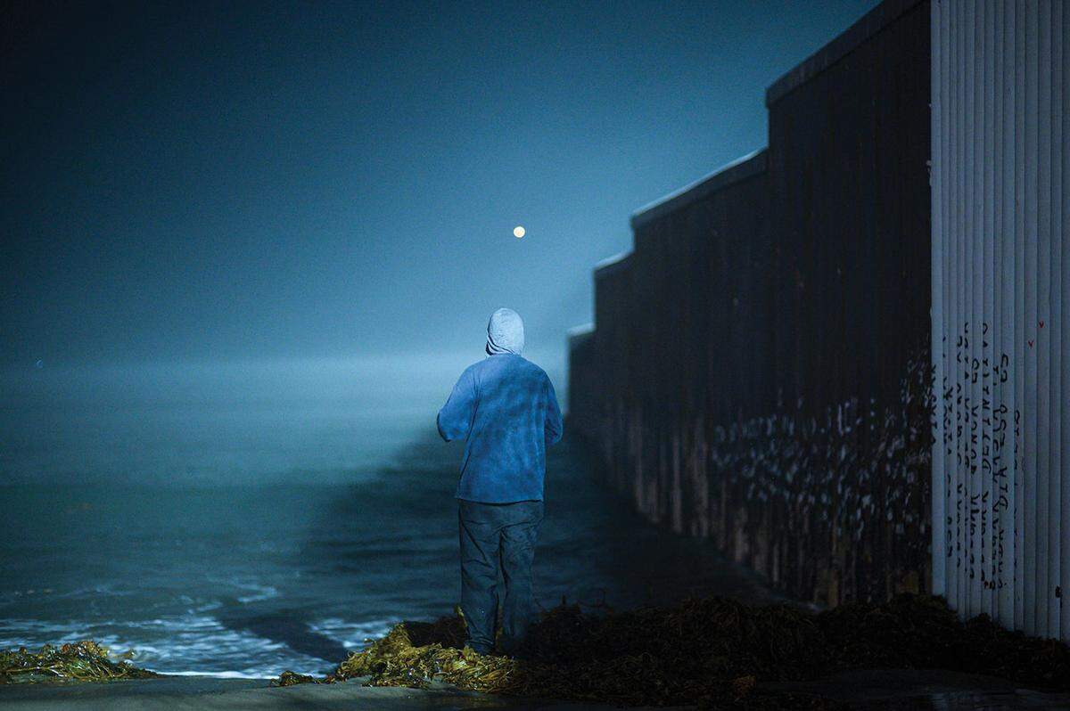 Ein Migrant aus Haiti steht an der Grenzmauer in Tijuana. Der Fotograf Denis Vejas sieht die Mauer als Symbol für Trennung, Vorherrschaft und Rassismus. Mit seinem Bild zeigt er, dass Reisen nicht nur von Neugier und Wunsch, sondern auch von Notwendigkeit getrieben sein kann.
