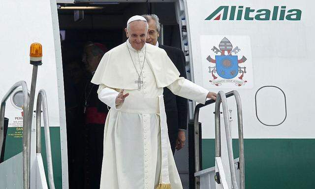 Pope Francis waves upon arrival at Antonio Carlos Jobim International Airport in Rio de Janeiro