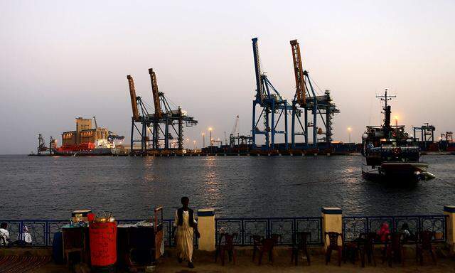 FILE PHOTO: A man stands opposite the modern port at the harbour in Port Sudan at Red Sea State