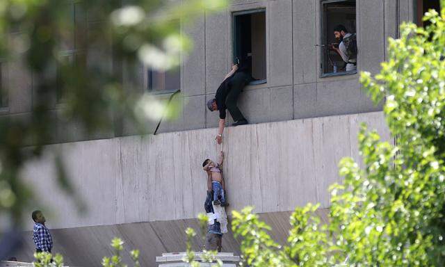 Der Terror erreicht Teheran: Ein Bub wird am Mittwoch aus dem iranischen Parlamentsgebäude gerettet.